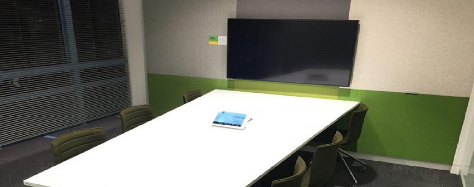 Fonterra Experience Centre meeting room with touchscreen on the desk and large display scrfeen