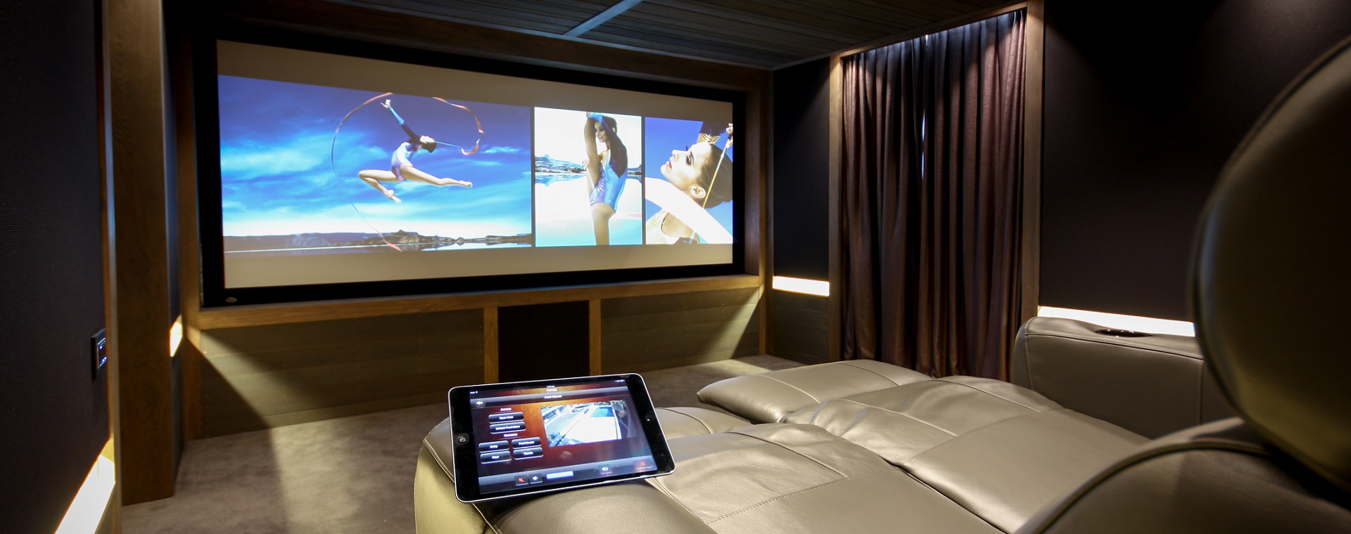 Home theatre with cinema style reclining chairs and touchscreen control of home entertainment