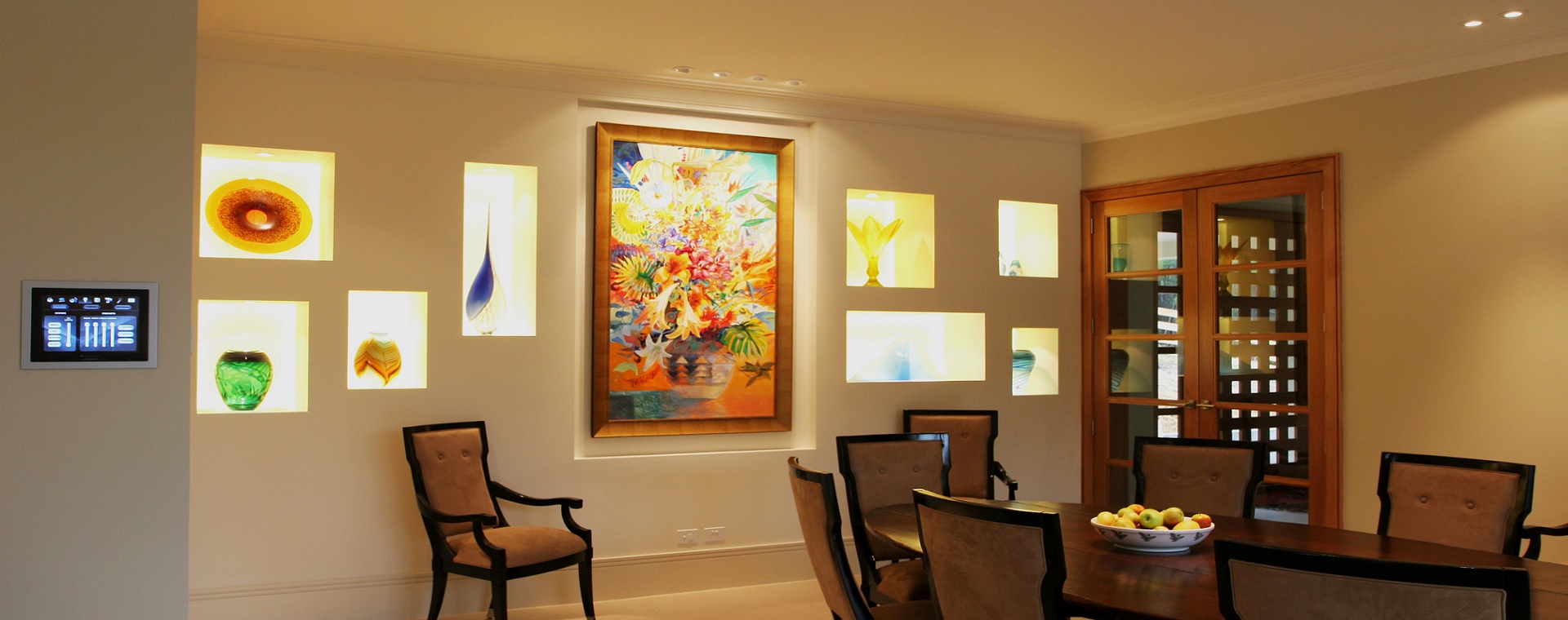 Formal dining room in a modern home featuring a home automation touchscreen controlling the art feature lights