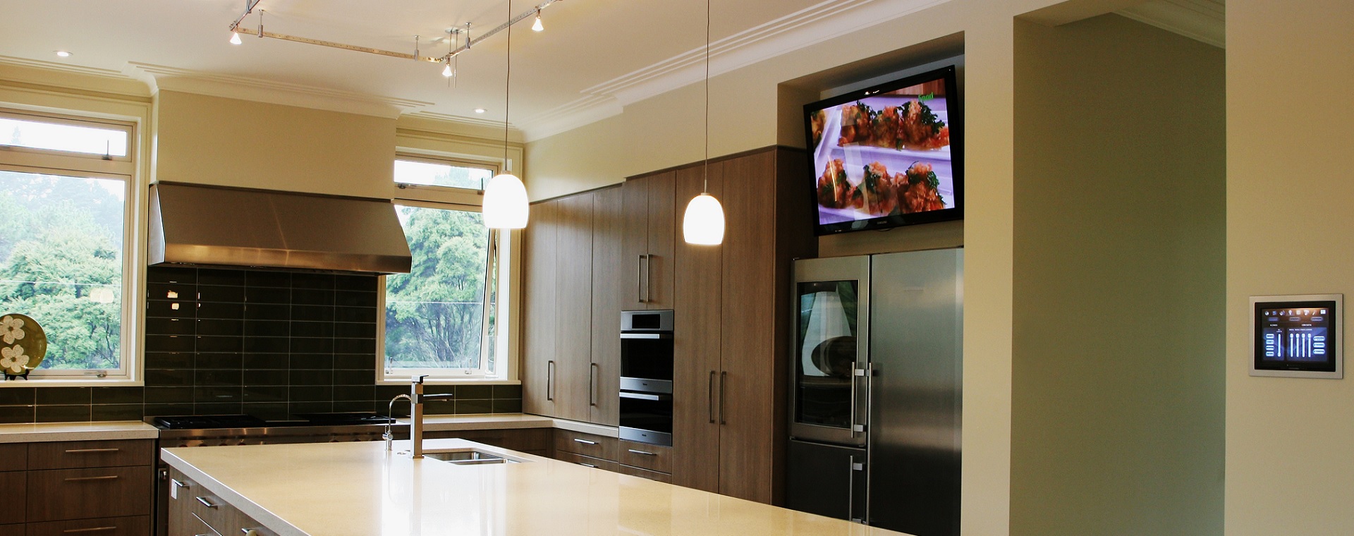 Modern kitchen with TV and touchscreen for control of entertainment, lighting and automation systems