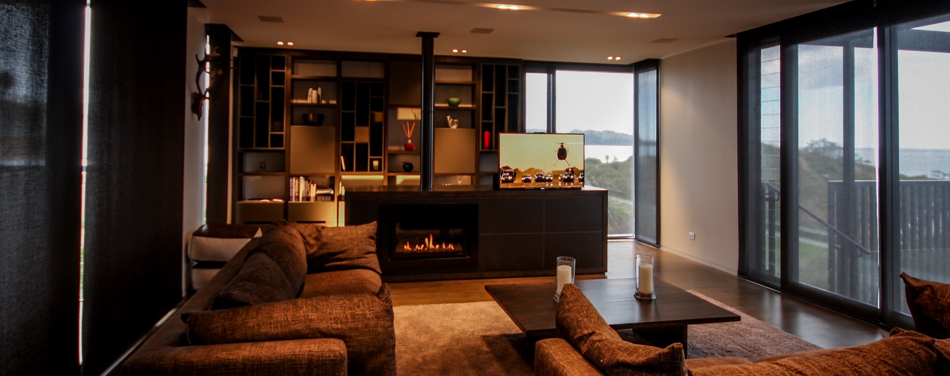 Cozy lounge with seaviews, a fireplace and TV featuring lighting and entertainment control via home automation