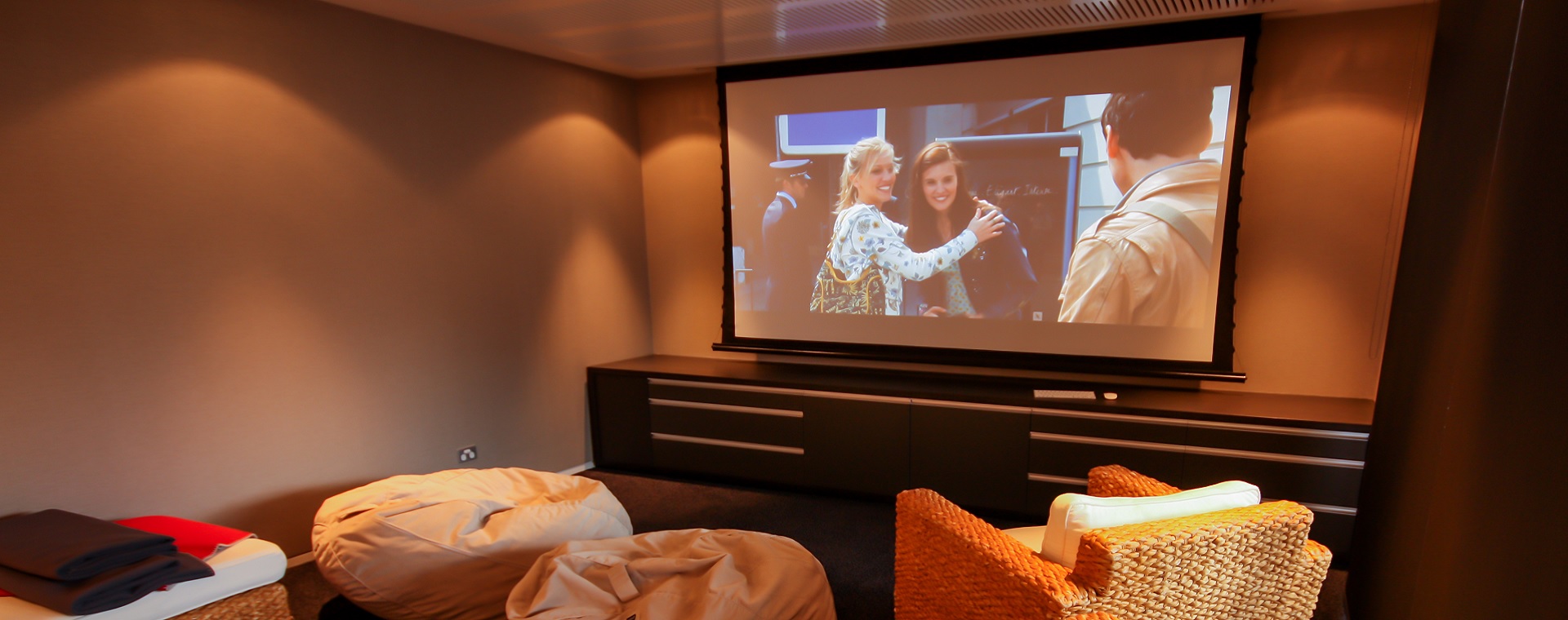 Comfy home threatre with drop-down projector screen, armchairs and beanbags