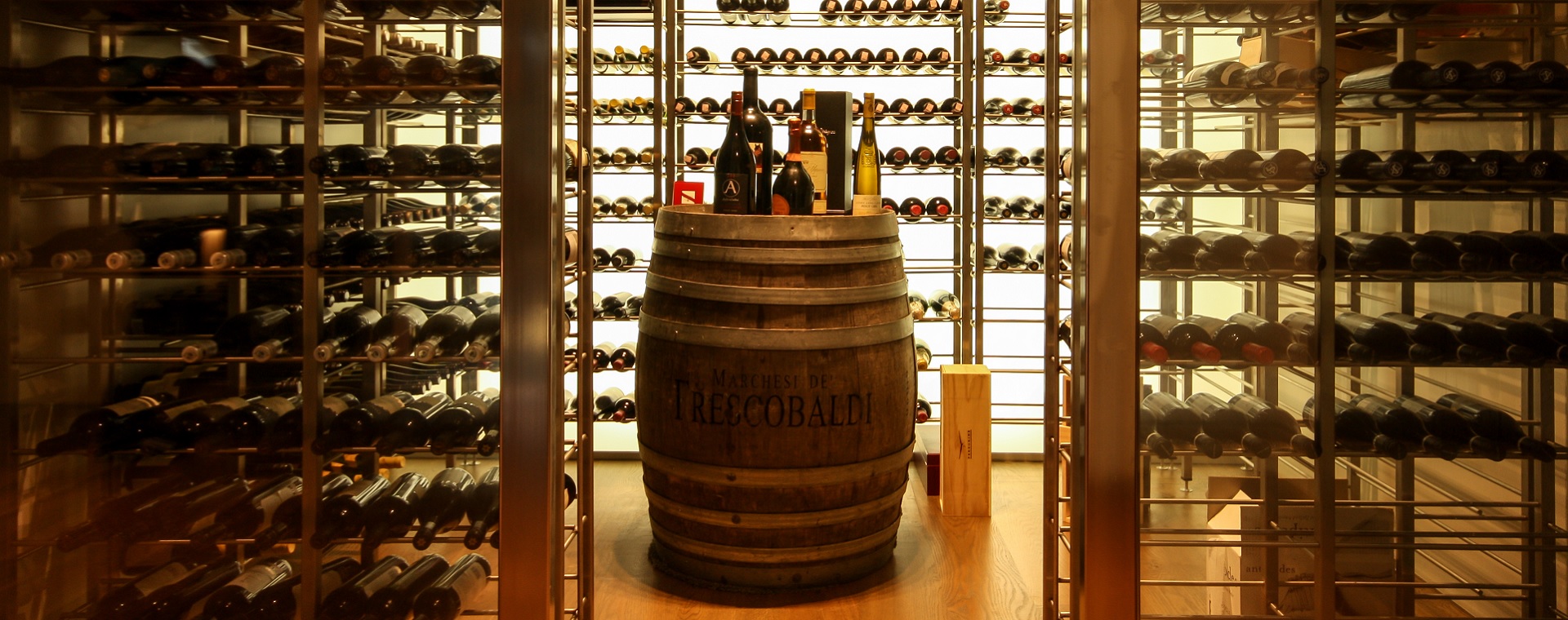 Automated and temperature controlled wine cellar featuring a wine barrel used as a bench