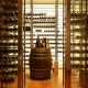 Wine bottles on barrel in a custom wine cellar featuring lighting, refrigeration and humidity control