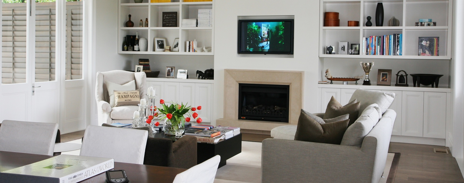 Modern family room with touchscreen control of entertainment system, and recessed TV over fireplace