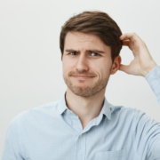 Man looking perturbed scratching his head