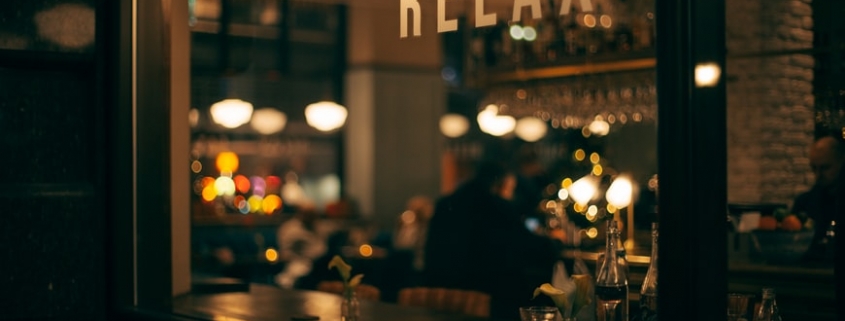 Restaurant window with 'relax' sign and warm glow lighting