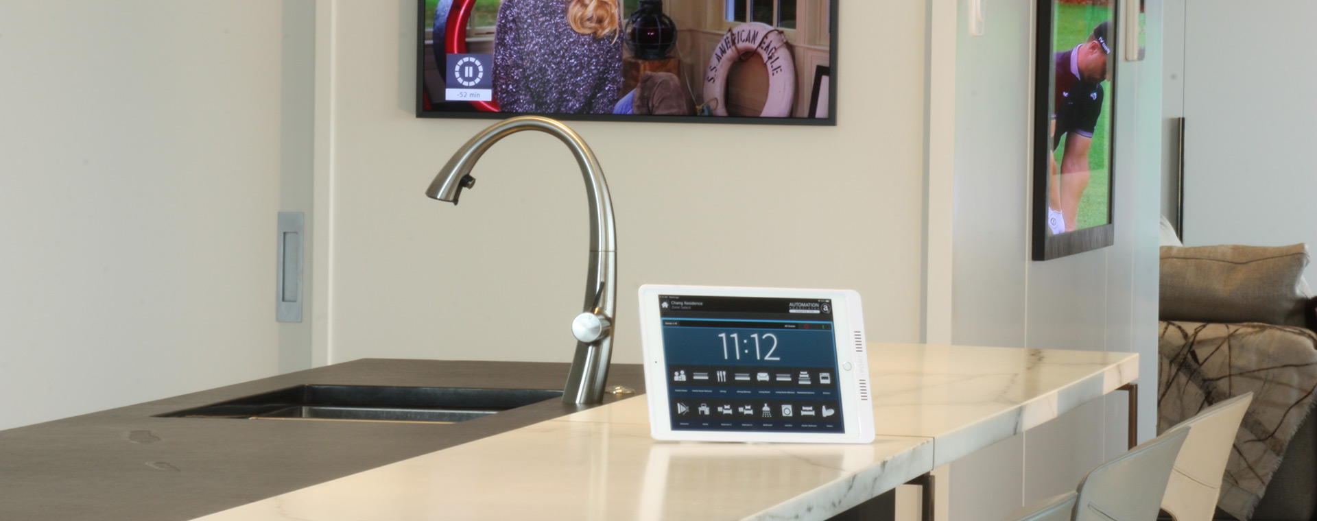 Kitchen TV and audio system controlled by a mobile tablet on kitchen bench