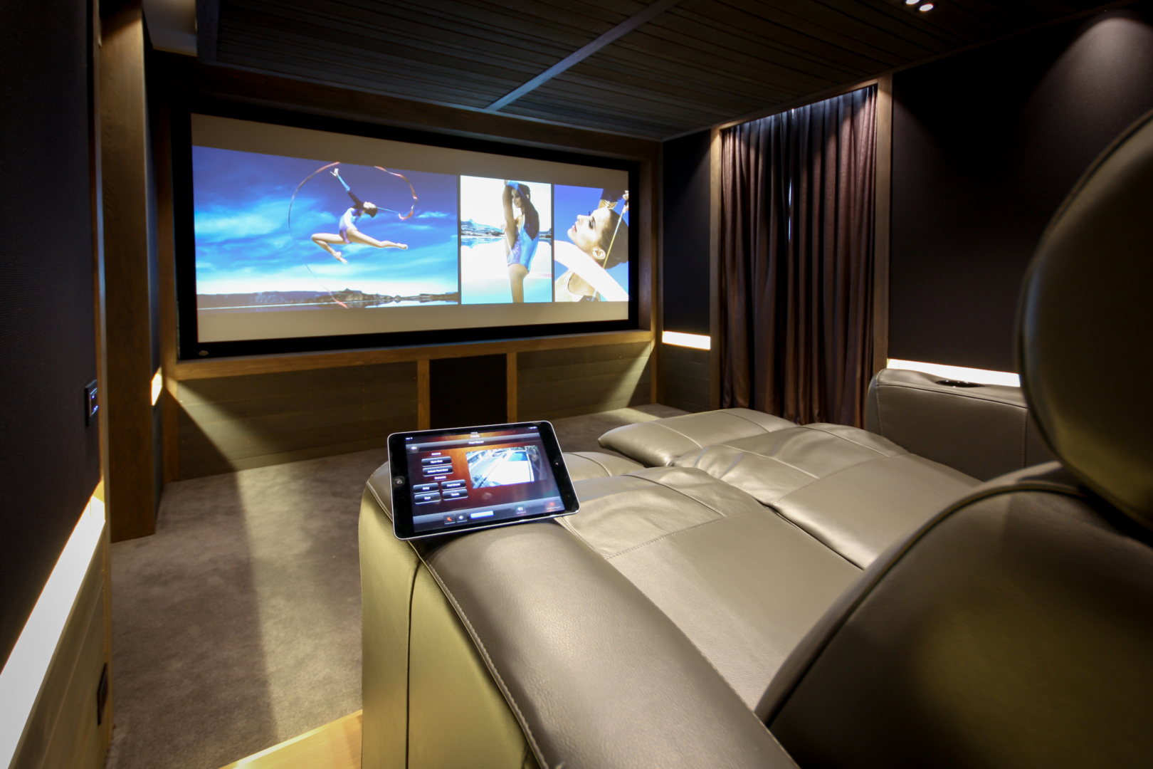 Home theatre with cinema style reclining chairs and touchscreen control of home entertainment