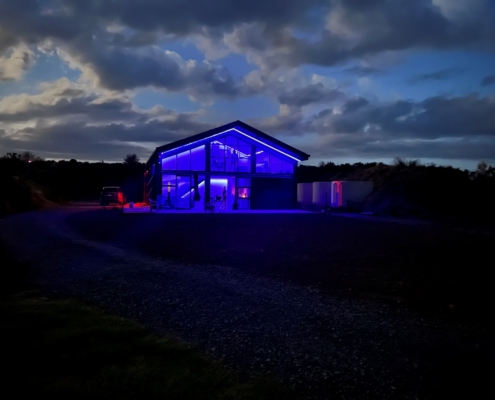 Off-grid, rural home at night showing blue LED lighting theme