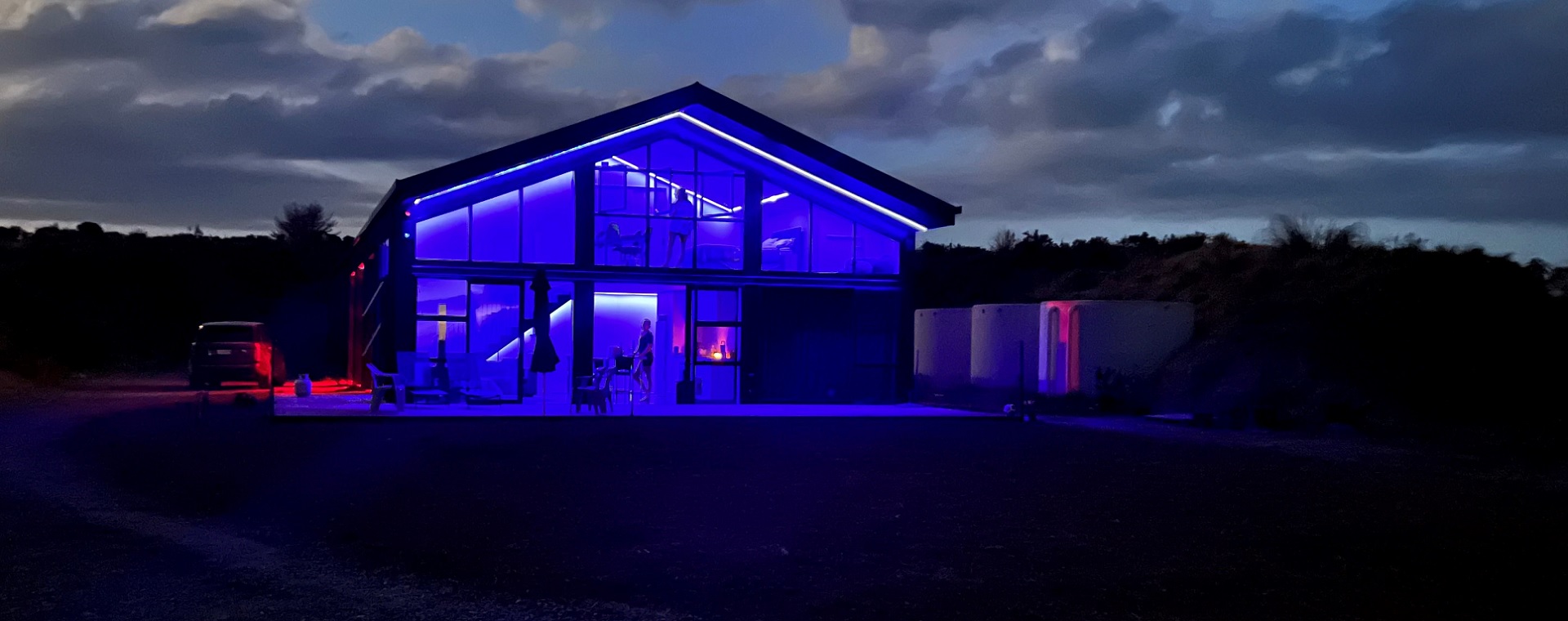 Off-grid, rural home at night showing blue LED lighting theme