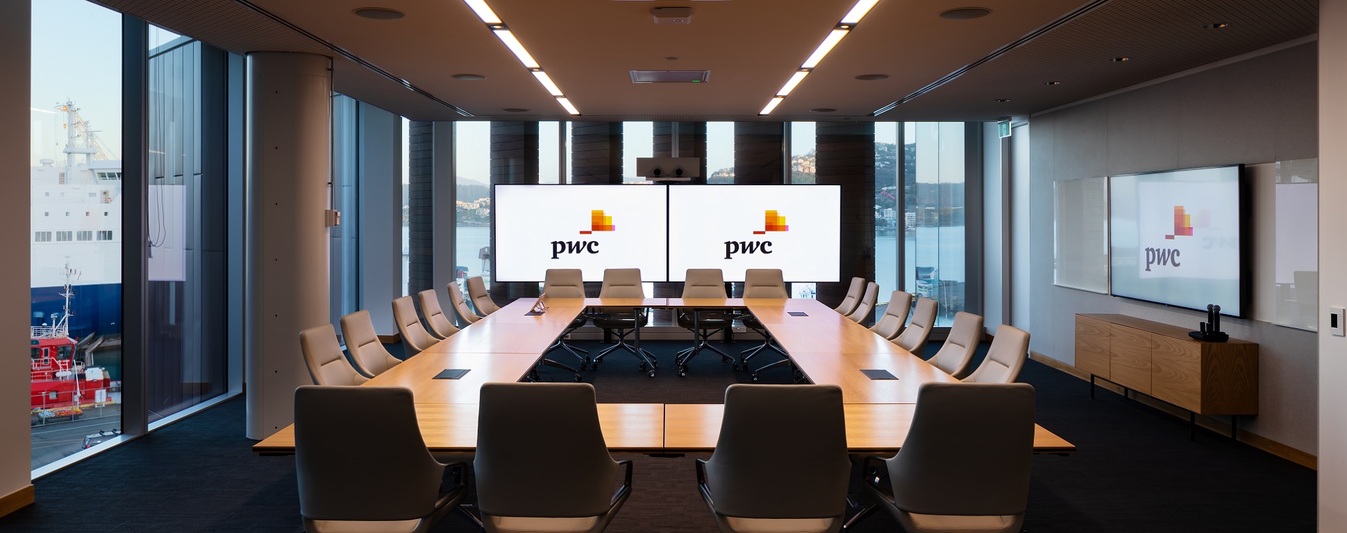 PwC large meeting room with board-room style seating and a 1 x 2 video wall for video conferencing and presentations